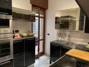una cocina con encimeras negras y electrodomésticos de acero inoxidable en Centro Storico, Piazza Carmine: La Casa di Angela en Reggio Calabria