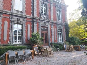 a building with chairs and tables in front of it at Château Lambert Hotel-Resto-Parking-Shuttle airport, 3 saloons, snooker, large terrasse in Charleroi