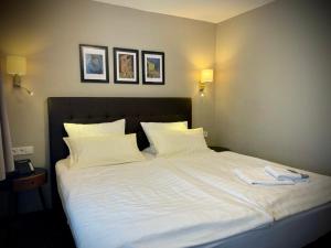 a large white bed with two towels on it at Hotel Regina in Ludwigshafen am Rhein