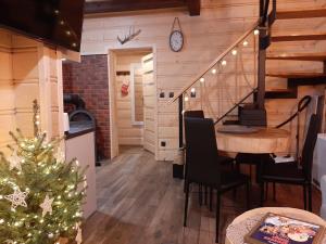 a room with a christmas tree and a table and a staircase at Domek na brzyzku in Kościelisko