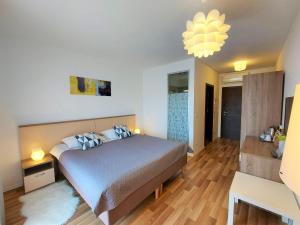 - une chambre avec un lit et un lustre dans l'établissement Rooms and Apartments IstraSoley, à Bale