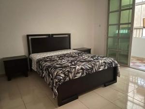 El AinにあるFurnished room in a villa in town center. With private bathroomのベッドルーム1室(ベッド1台、白黒の掛け布団付)