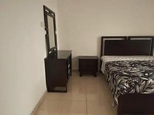 Schlafzimmer mit einem Bett, einer Kommode und einem Spiegel in der Unterkunft Furnished room in a villa in town center. With private bathroom in El Ain