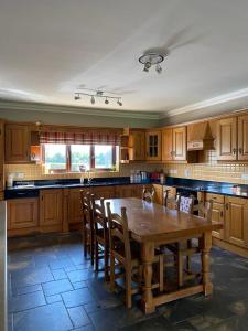 a large kitchen with a wooden table and chairs at Gallagh Guest House self catering h18r252 Eircode in Monaghan