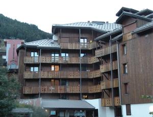 a large building with wooden balconies on it at Au Coeur De La Station in Les Deux Alpes