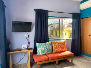 a living room with a couch and a window at Apartamento 1 in Sayulita