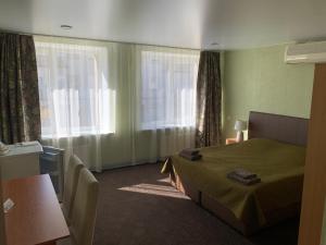 ein Hotelzimmer mit einem Bett und einem Fenster in der Unterkunft Laisves 30 in Mažeikiai