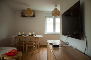 un salon avec une table et une télévision dans l'établissement Chang Thai apartments, à Ljubljana