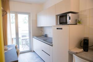 uma pequena cozinha com frigorífico e micro-ondas em Marigold Residence em Roseto degli Abruzzi