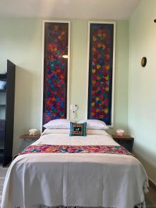 a bedroom with a large bed with two windows at Apartamento 2 in Sayulita