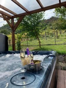 a hot tub with a glass of wine and a bowl of food at Smaragd in Doba