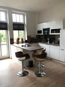 a kitchen with a table and two bar stools at Apartment am Landtag in Erfurt