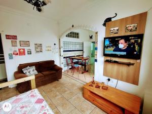 uma sala de estar com um sofá e uma televisão de ecrã plano em Apê da Mônica em Balneário Camboriú