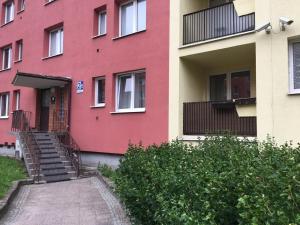 a red building with stairs leading to the entrance at Hugo Apartment Gdansk in Gdańsk