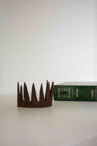 een plastic kroon naast een groen boek bij Le Roitelet - Suite d'hôtes privative in Montcavrel