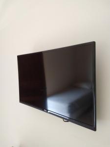 una TV a schermo piatto appesa a una parete di Ubatuba Suites Itamambuca a Ubatuba