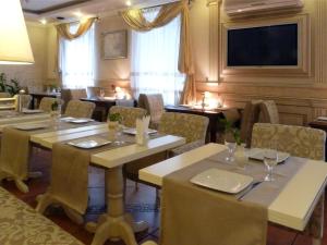 a restaurant with tables and chairs and a flat screen tv at Penthouse Apartment in Hotel Eney in Lviv