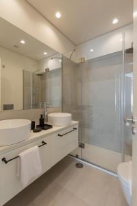 ein Badezimmer mit zwei Waschbecken und einer Glasdusche in der Unterkunft ORM Antero Apartment in Porto