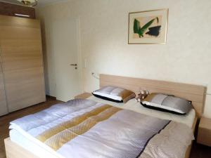 - une chambre avec un grand lit blanc dans l'établissement Primeurs appartement haut standing de 85 m², Luxembourg-Kirchberg, à Luxembourg