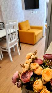 ein Blumenstrauß auf einem Tisch im Wohnzimmer in der Unterkunft Yellow Apartment in Tbilisi City