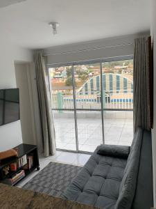 - un salon avec un canapé et une grande fenêtre dans l'établissement Esplanada Apiai, à Apiaí