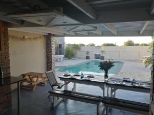 a patio with a table and a swimming pool at 420 on Cape in Port Elizabeth