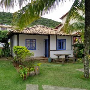 una casa con una mesa de picnic delante de ella en CASA NO PERÓ - CABO FRIO, en Cabo Frío