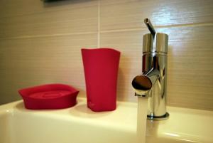 a sink with a soap dispenser next to it at Trigrana Vacanze Hotel in Castelluzzo