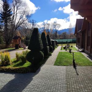 a walkway with bushes and trees in a park at Mini Hotel Zakrut in Tatariv +115 photos