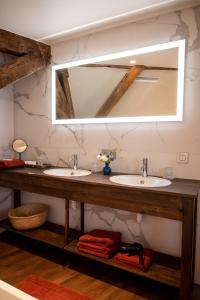 a bathroom with two sinks and a large mirror at B&B l'histoire de l'éclair in Bruges