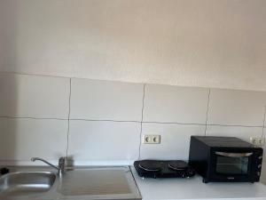 a microwave sitting on a kitchen counter next to a sink at NEW beautiful place in the village near Leipzig in Elsteraue