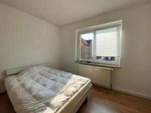 a white bedroom with a bed and a window at NEW beautiful place in the village near Leipzig in Elsteraue