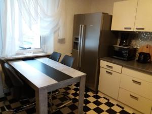 eine Küche mit einem Tisch und einem Kühlschrank aus Edelstahl in der Unterkunft Ferienwohnung Volskyy in Trier