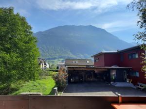 una vista de una casa con una montaña en el fondo en Haus Nussbaumweg 6, en Giswil