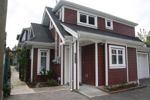 una casa rossa con finiture bianche di Vancouver Traveller Cottage a Vancouver
