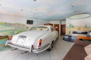 a white car parked in a room with a bedroom at Swiss-Chalet Merlischachen - Romantik Schloss-Hotel am See in Küssnacht