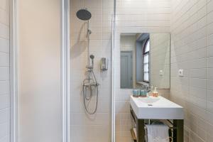 W łazience znajduje się prysznic, umywalka i lustro. w obiekcie Praça Guest House w mieście Arouca