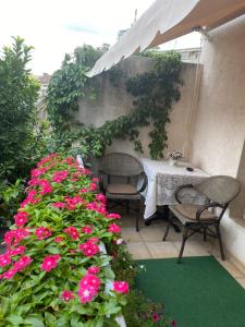 a table and chairs on a patio with pink flowers at Apartments Skadarlija in Belgrade