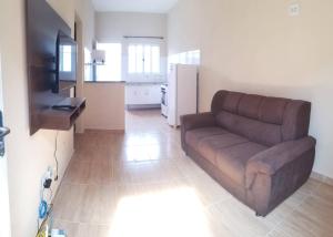 a living room with a brown couch and a kitchen at Pelourinho in Olímpia