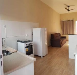 a kitchen with a stove and a white refrigerator at Pelourinho in Olímpia