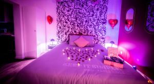 ein Schlafzimmer mit einem Bett mit einem aus Ballons gefertigten Herz in der Unterkunft LoveSparadise -Suite Le Secret in Saints