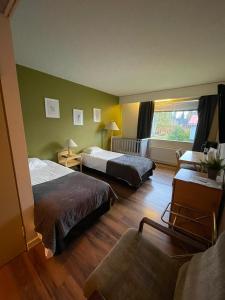 ein Hotelzimmer mit zwei Betten und einer Couch in der Unterkunft hotelli ravintola kurenkoski in Pudasjärvi