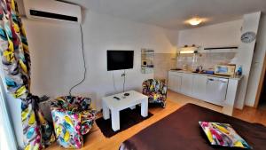 a living room with a tv and a table and chairs at Fibos Studios in Ohrid