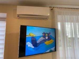 a flat screen tv hanging on a wall at Апартаменты в самом центре города in Chernihiv