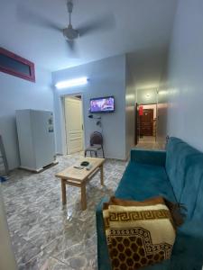 ALRahman Building في أسوان: غرفة معيشة مع أريكة زرقاء وطاولة