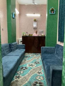 - une salle d'attente avec deux canapés bleus et un bar dans l'établissement ALRahman Building, à Assouan