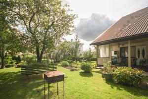 un patio con un banco y una casa en Dina Apartments, en Druskininkai