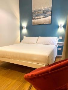 a bedroom with a white bed and a red couch at La Ripa Camere Vernazza - Stradivari Luxury Apartment in Vernazza