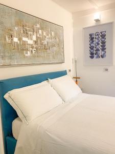 a bed with two pillows and a painting on the wall at La Ripa Camere Vernazza - The Spinnaker Suite in Vernazza