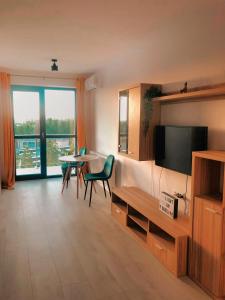 a living room with a television and a table with chairs at Hils Pallady Bucharest apartments in Bucharest